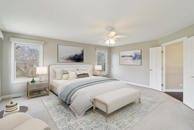carpeted bedroom with multiple windows, visible vents, ceiling fan, and baseboards