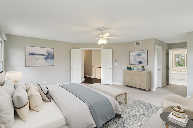 bedroom featuring connected bathroom, light colored carpet, ceiling fan, baseboards, and visible vents