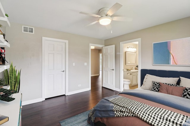 bedroom featuring connected bathroom, visible vents, baseboards, wood finished floors, and a ceiling fan