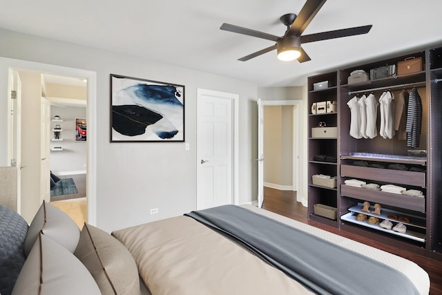 bedroom with ceiling fan, wood finished floors, and baseboards