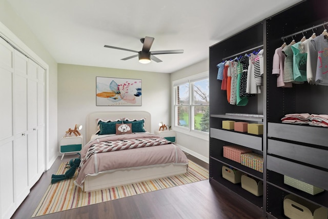 bedroom with a closet, a ceiling fan, wood finished floors, and baseboards