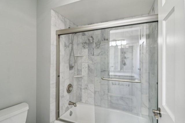 bathroom featuring shower / bath combination with glass door and toilet