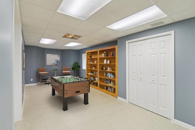 game room featuring a drop ceiling and baseboards