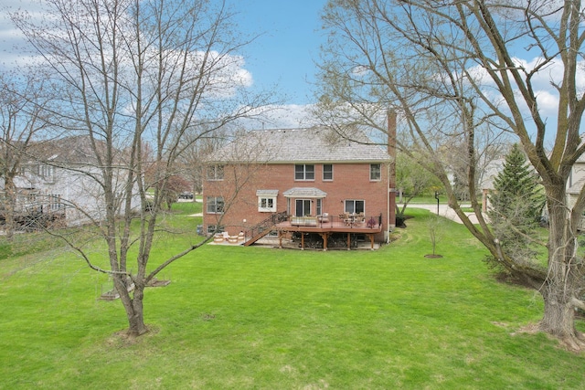 back of house featuring a deck, brick siding, a yard, and stairs