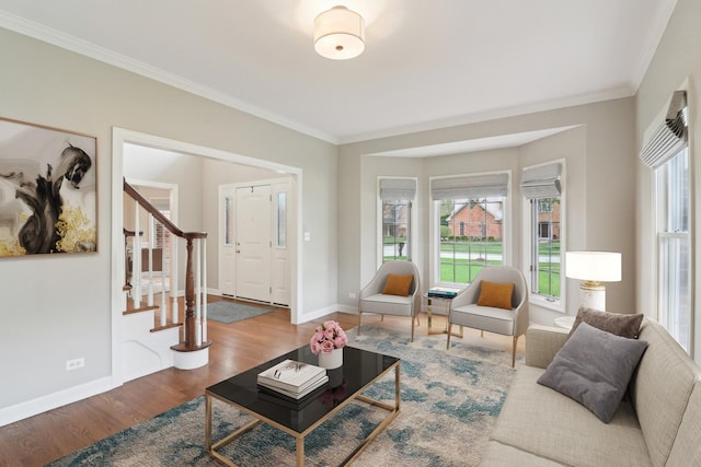 living area featuring stairway, wood finished floors, a wealth of natural light, and ornamental molding