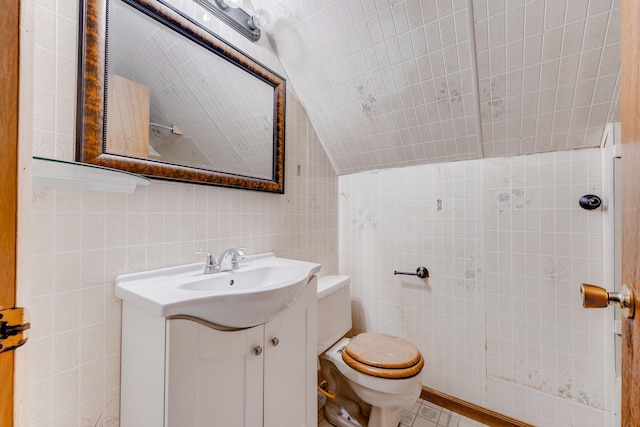 2147 N Latrobe Ave, Chicago, IL 60639 - bathroom with lofted ceiling, toilet, vanity, and tile walls
