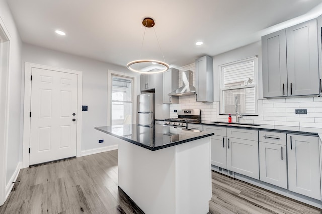 2147 N Latrobe Ave, Chicago, IL 60639 - kitchen featuring wall chimney exhaust hood, stainless steel appliances, a sink, and light wood-style floors