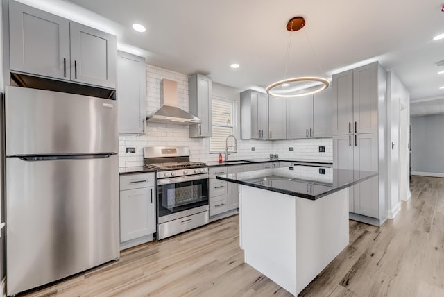 2147 N Latrobe Ave, Chicago, IL 60639 - kitchen featuring wall chimney exhaust hood, stainless steel appliances, backsplash, and light wood-type flooring