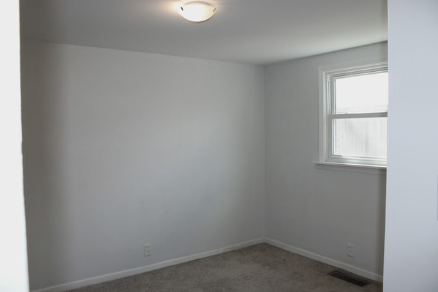 unfurnished room with baseboards, carpet flooring, and visible vents
