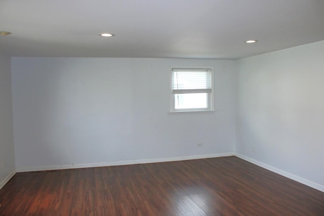 spare room featuring recessed lighting, baseboards, and dark wood-style flooring
