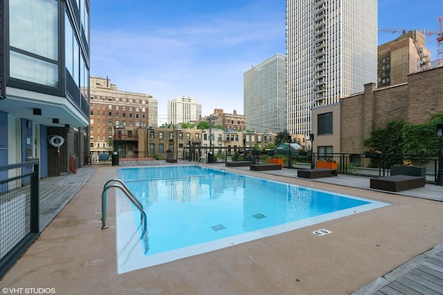 community pool with a view of city and a patio