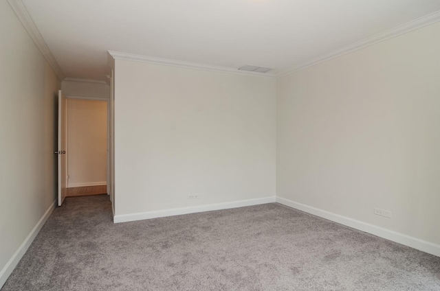 unfurnished room with crown molding, carpet flooring, baseboards, and visible vents