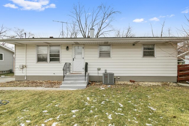 single story home featuring cooling unit and a front yard