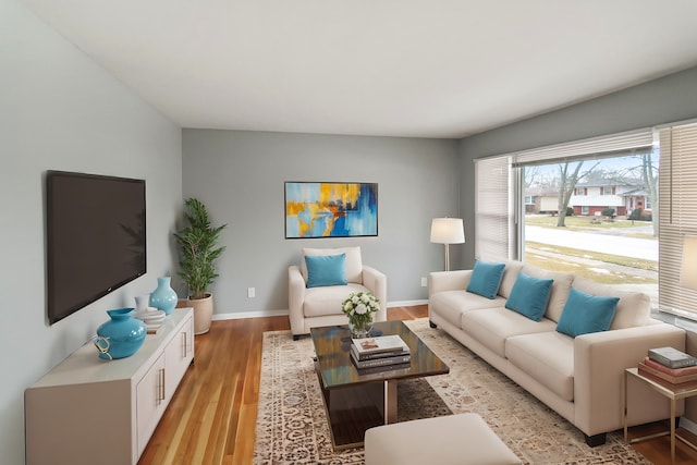living area featuring baseboards and light wood-style flooring