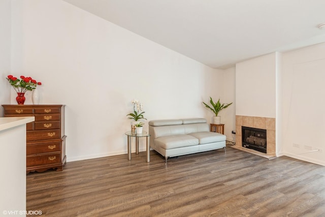 sitting room with baseboards, wood finished floors, and a fireplace
