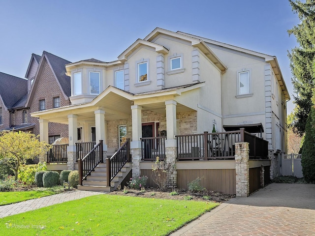 view of front of house with a porch, a front lawn, and stucco siding