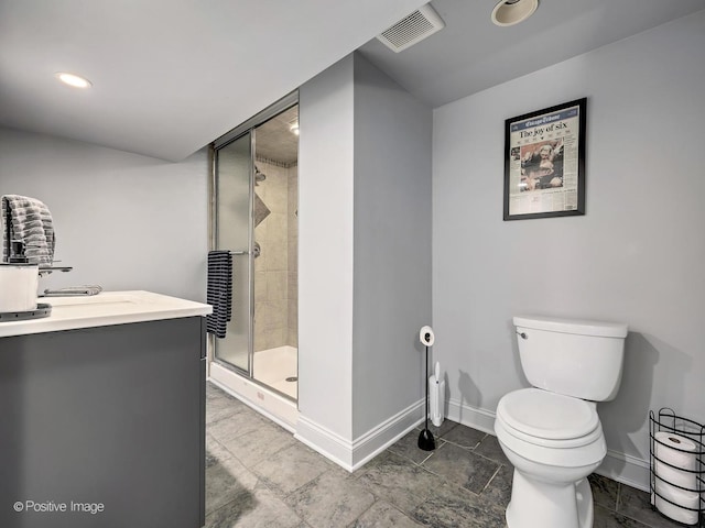 bathroom with a shower stall, toilet, vanity, baseboards, and visible vents
