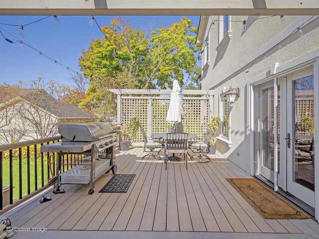 wooden deck with outdoor dining area, a pergola, and a grill