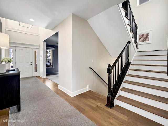 foyer entrance featuring recessed lighting, baseboards, wood finished floors, and stairs