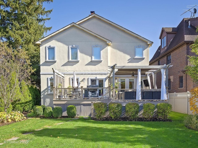 back of house featuring a pergola, a lawn, stucco siding, and fence