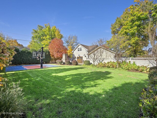 view of yard featuring basketball court and fence