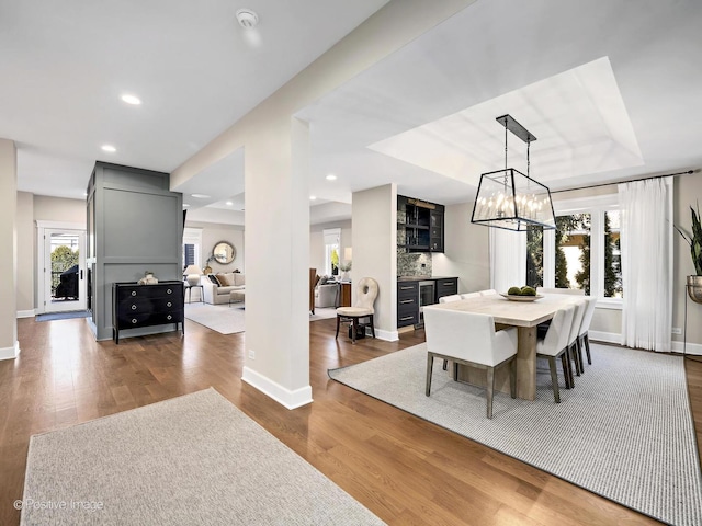 dining room featuring recessed lighting, baseboards, wood finished floors, and an inviting chandelier
