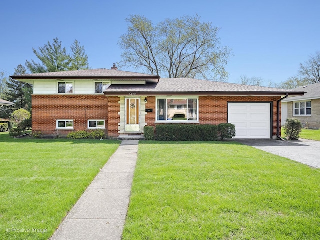 tri-level home featuring a garage, a front yard, brick siding, and aphalt driveway