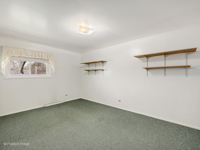 empty room with carpet floors, baseboards, and baseboard heating