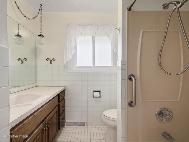 full bath with vanity, tile patterned flooring, toilet, tile walls, and  shower combination