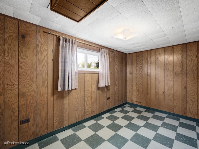 spare room with dark floors and wood walls