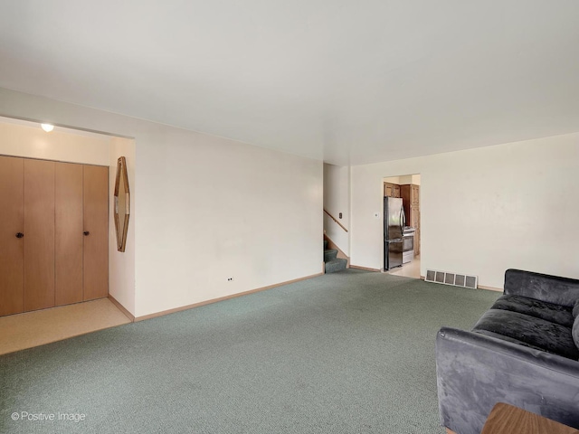 living area with stairway, baseboards, light colored carpet, and visible vents