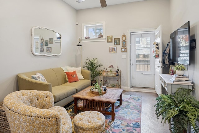 living room with wood finished floors, plenty of natural light, a ceiling fan, and baseboards