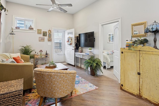 living area with ceiling fan and wood finished floors