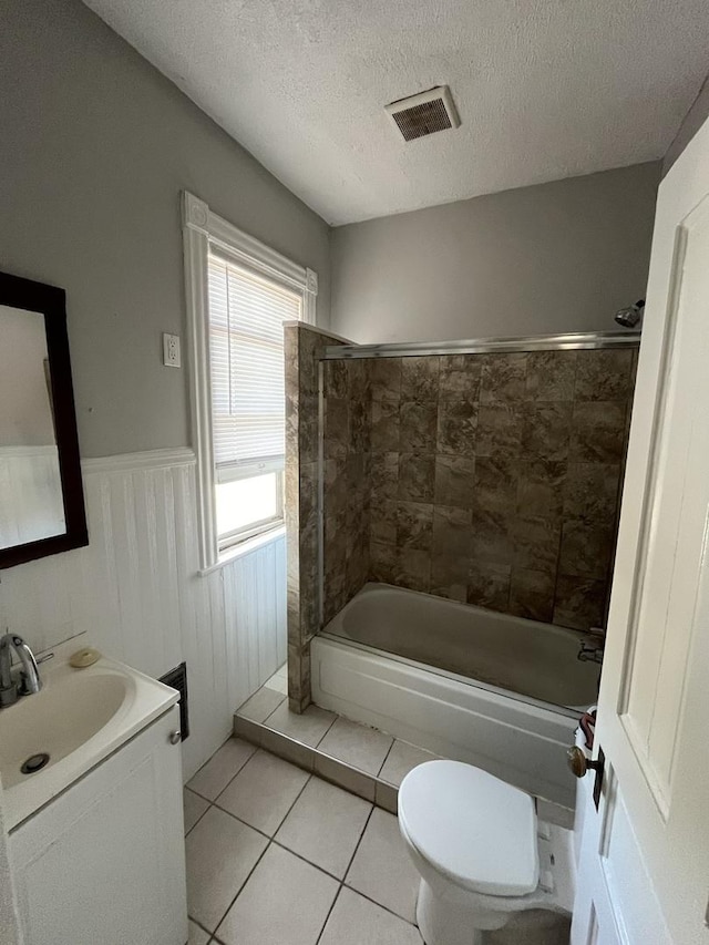 506 E Chestnut St, Bloomington, IL 61701 - bathroom with tile patterned floors, toilet, wainscoting, visible vents, and washtub / shower combination