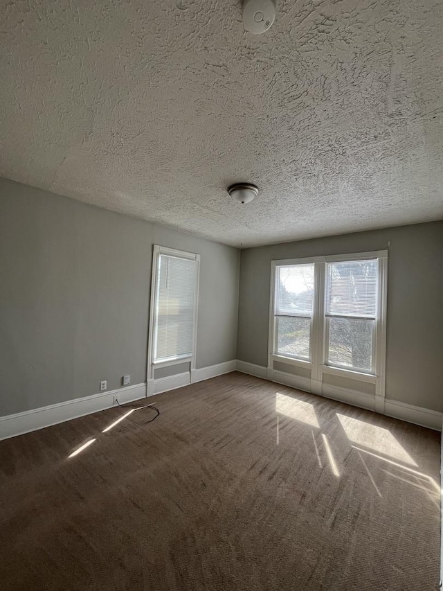 506 E Chestnut St, Bloomington, IL 61701 - spare room featuring a textured ceiling, carpet flooring, and baseboards