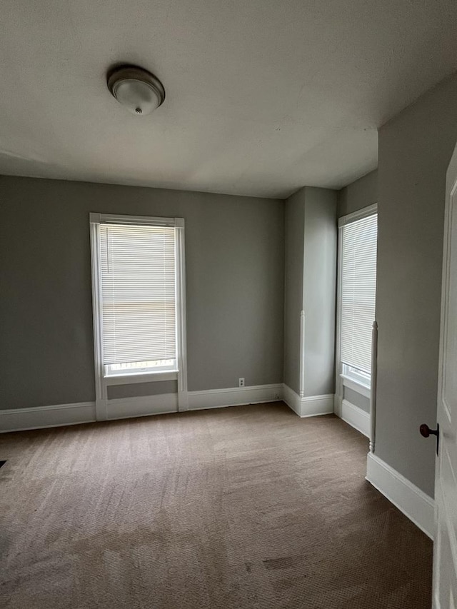 506 E Chestnut St, Bloomington, IL 61701 - carpeted empty room with baseboards
