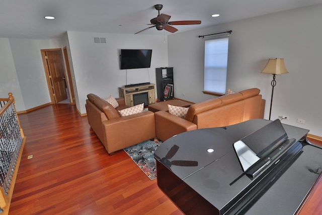 living room with baseboards, ceiling fan, wood finished floors, and visible vents