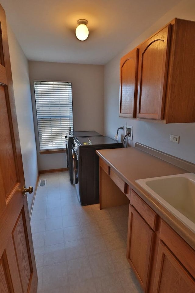 washroom with independent washer and dryer, visible vents, cabinet space, baseboards, and light floors