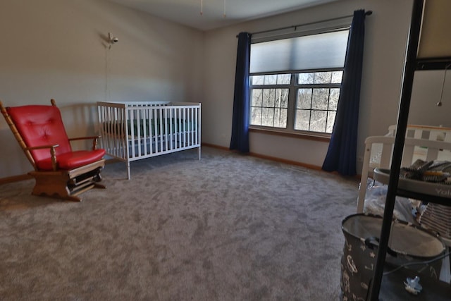 carpeted bedroom featuring baseboards and a nursery area
