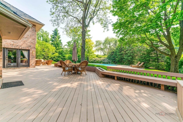 1330 Kurtis Ln, Lake Forest, IL 60045 - wooden deck with an outdoor pool, outdoor dining space, view of wooded area, and french doors