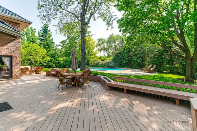 1330 Kurtis Ln, Lake Forest, IL 60045 - deck featuring an outdoor pool, outdoor lounge area, outdoor dining space, and view of wooded area