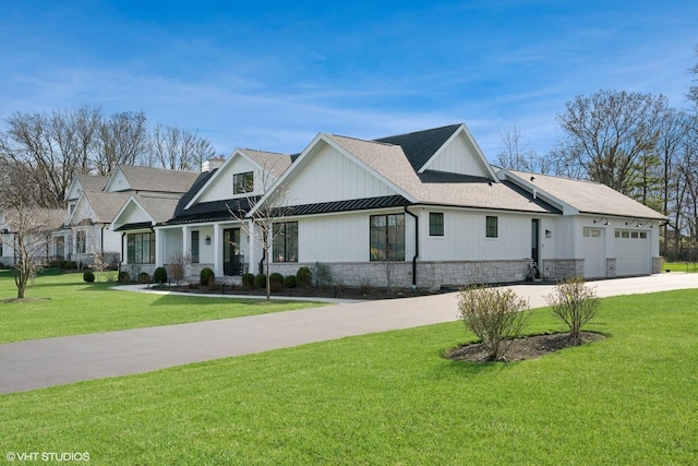 modern inspired farmhouse featuring driveway, an attached garage, stone siding, a front lawn, and a shingled roof