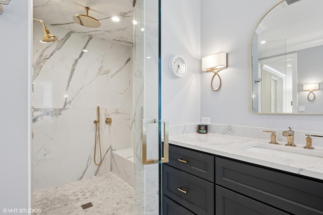 bathroom with vanity and a marble finish shower