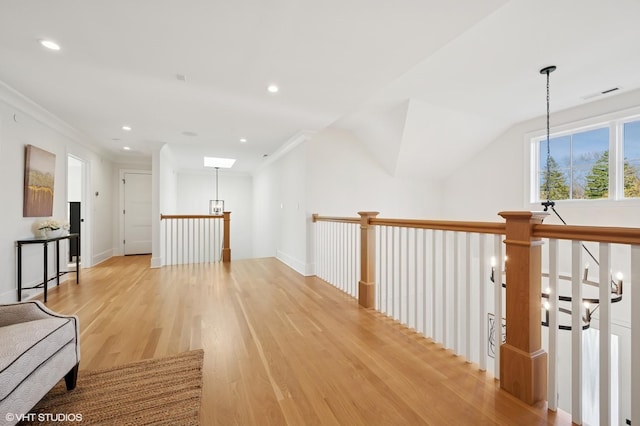 hall with light wood finished floors, recessed lighting, an upstairs landing, and ornamental molding