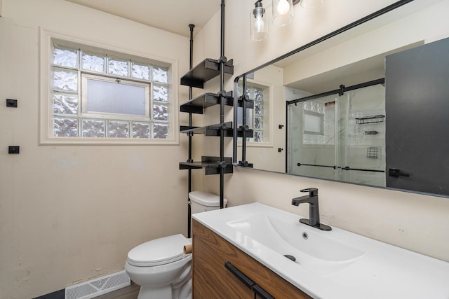 bathroom with vanity, visible vents, a shower stall, and toilet