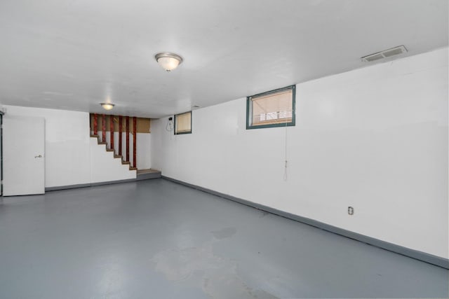basement featuring stairway, baseboards, and visible vents