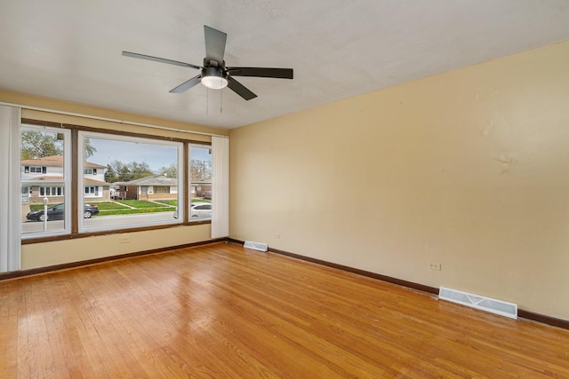 unfurnished room with visible vents, light wood finished floors, baseboards, and ceiling fan