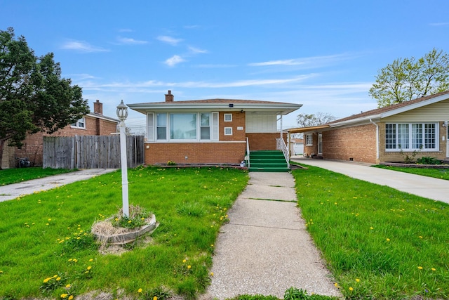 bungalow featuring brick siding, fence, and a front yard