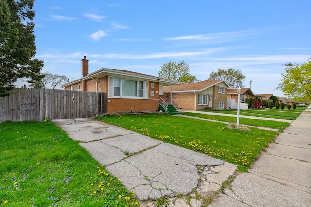 bungalow with driveway, a chimney, fence, brick siding, and a front yard