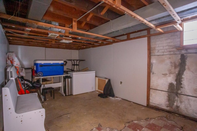 below grade area featuring fridge